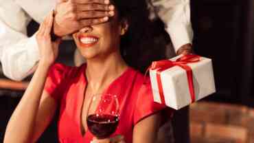 A guy covering the eyes of a woman to show a surprise