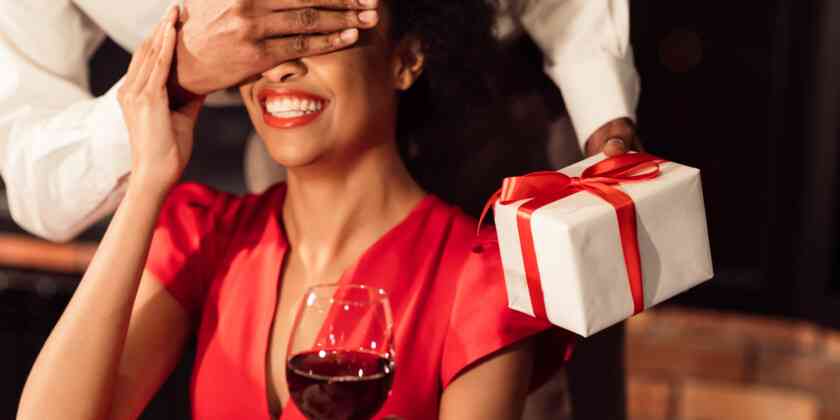 A guy covering the eyes of a woman to show a surprise