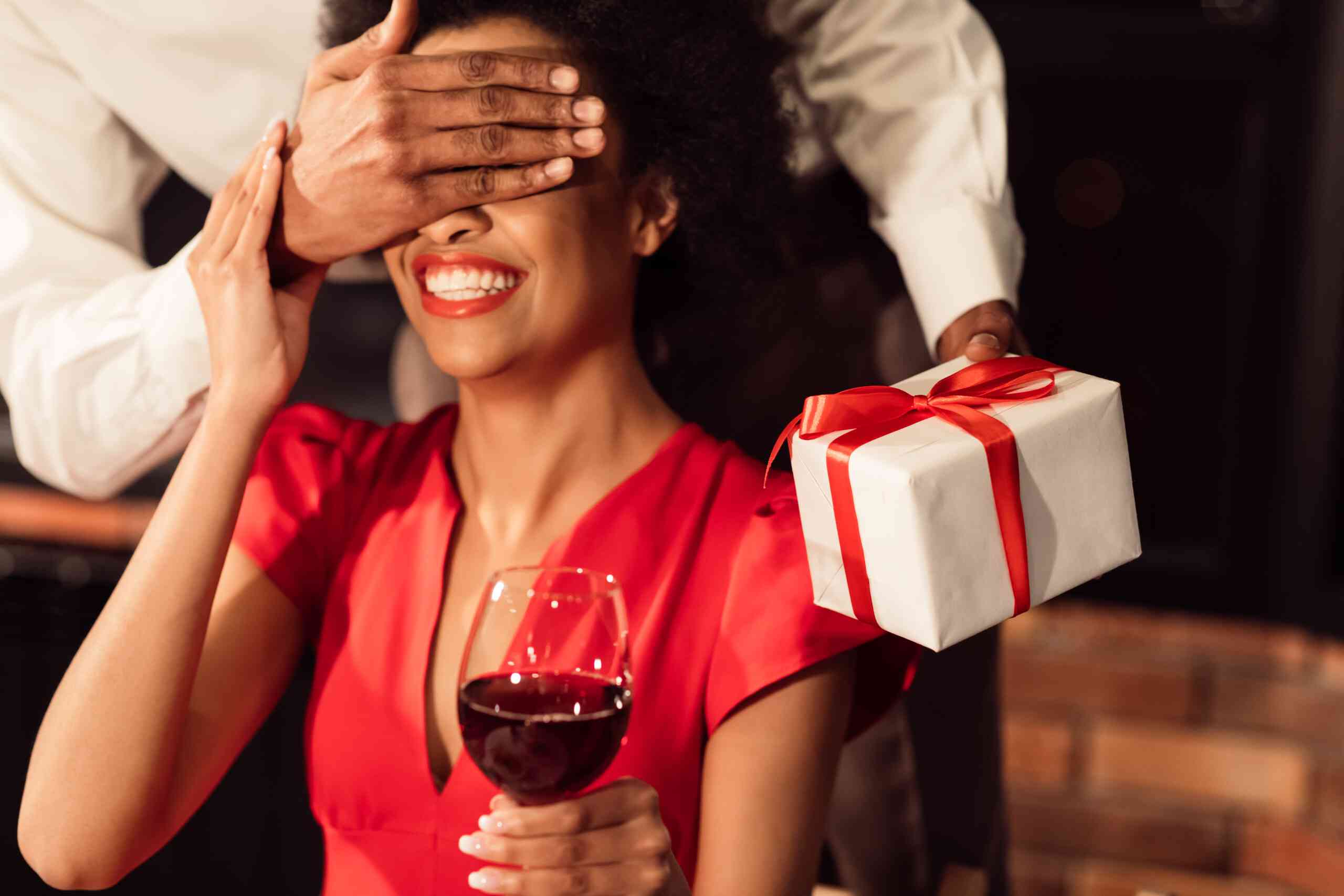 A guy covering the eyes of a woman to show a surprise